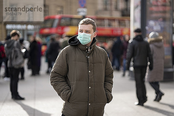 Junger Mann mit Gesichtsmaske  pendelt in der Stadt  St. Petersburg  Russland