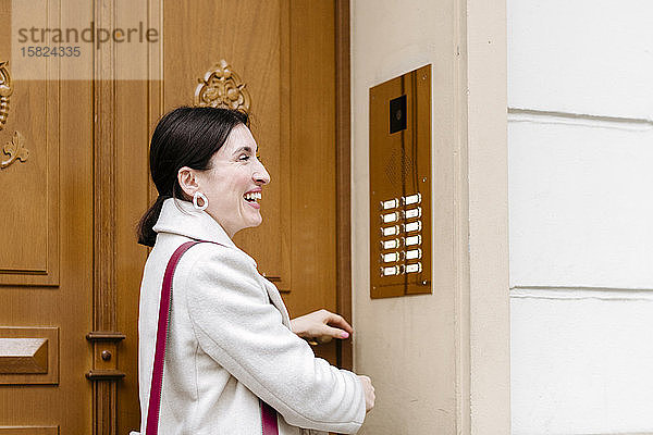 Lächelnde Frau öffnet Tür