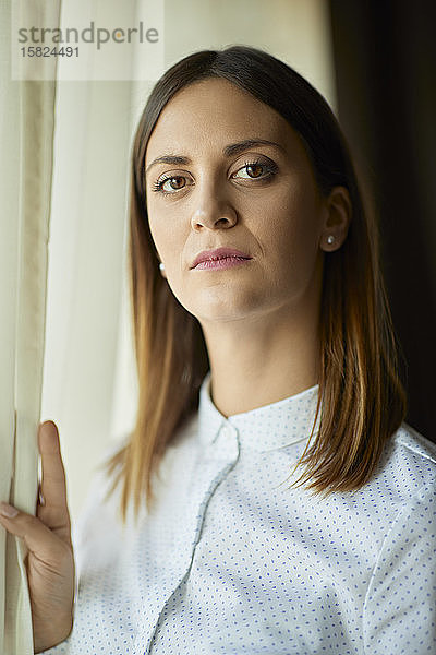 Porträt einer seriösen Geschäftsfrau am Fenster