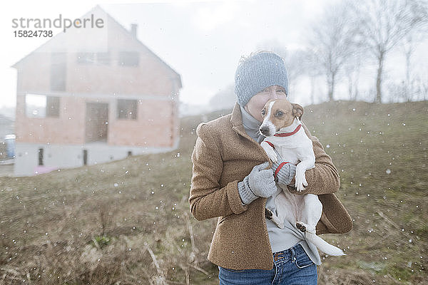 Porträt einer reifen Frau mit ihrem Hund am Wintertag