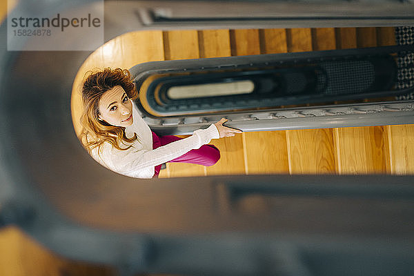 Porträt einer jungen Frau im Treppenhaus mit Blick nach oben