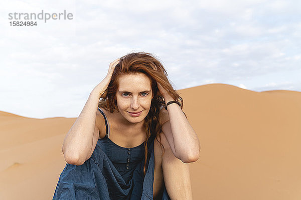 Porträt einer lächelnden rothaarigen jungen Frau in der Wüste Sahara  Merzouga  Marokko