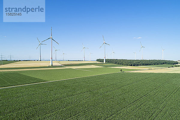 Deutschland  Bayern  Drone-Ansicht grüner Landschaftsfelder im Sommer mit Windpark im Hintergrund