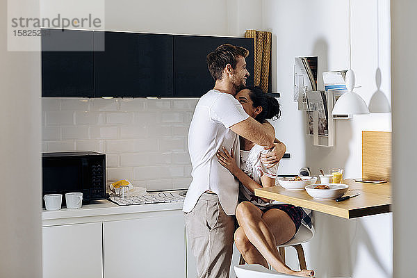 Zärtliches junges Paar am Morgen in der Küche