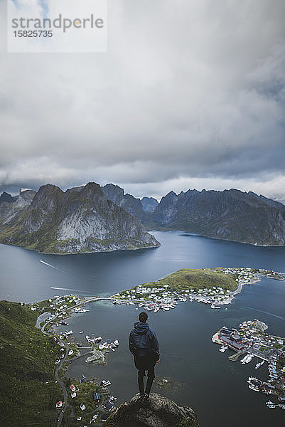 Norwegen  Lofoten  Reine  Mann schaut vom Reinebringen auf den Fjord