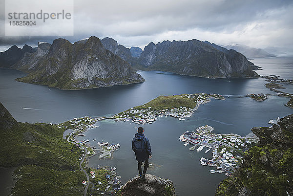 Norwegen  Lofoten  Reine  Mann schaut vom Reinebringen auf den Fjord