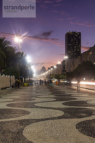 Schöne Aussicht auf den Sonnenuntergang auf den Spaziergang und die Gebäude am Copacabana-Strand