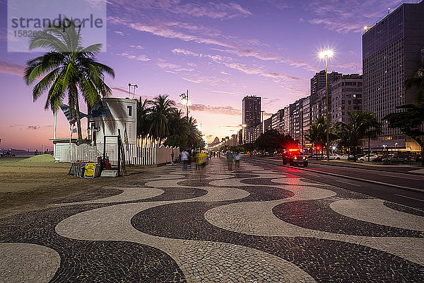 Schöne Aussicht auf den Sonnenuntergang auf den Spaziergang und die Gebäude am Copacabana-Strand