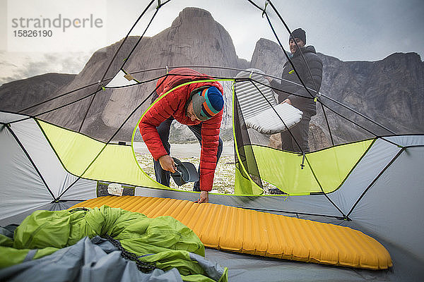 Zwei Männer haben während des Kletterausflugs in ihrem Zelt Schlafkissen aufgestellt.