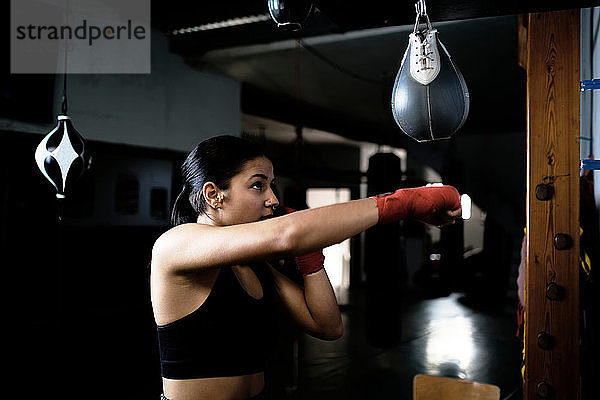 junge Frau  die im Fitnessstudio Boxen übt