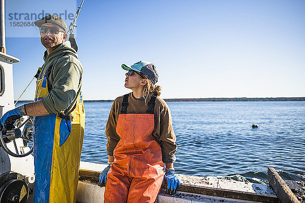 Frau und Mann arbeiten auf einem Muschelboot in der Narragansett Bay