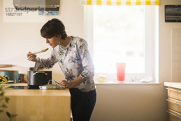 eine junge Frau  die zu Hause in einer Küche kocht