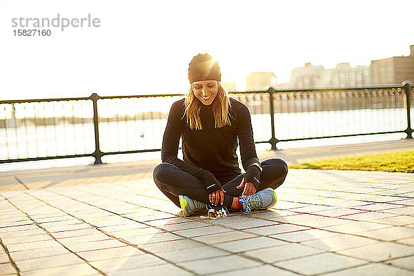 Ein fröhliches Porträt einer Läuferin im Gegenlicht in Ruhe.