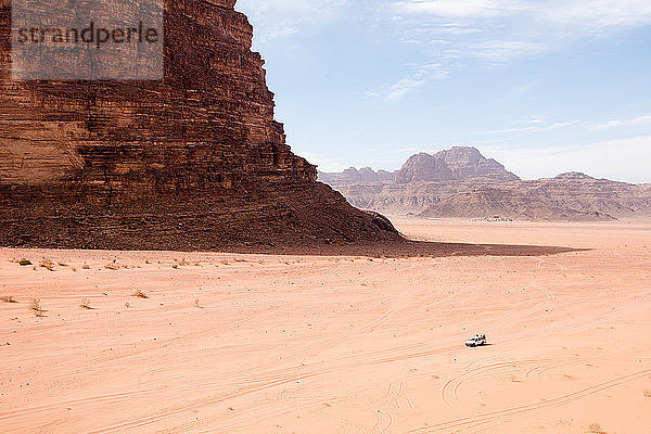 Touristen erkunden die Weite der Wüste Wadi Rum in Jordanien.