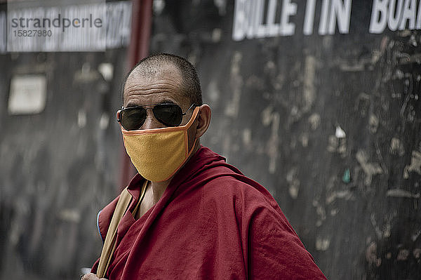 Mönch in den Straßen von Leh mit Kasaya-Gewand und Anti-Verschmutzungsmaske