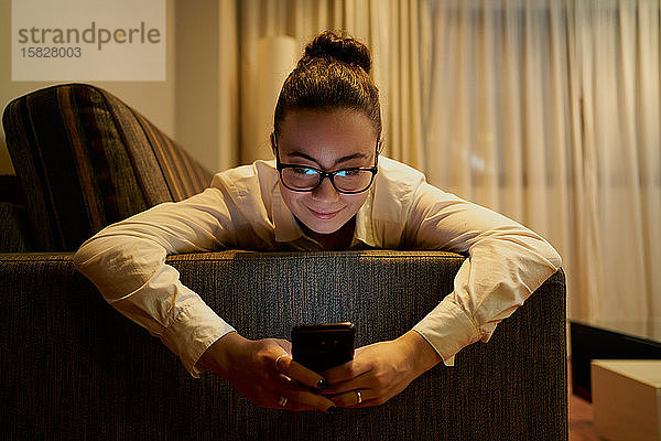 Junge Frau  die abends mit dem Laptop arbeitet