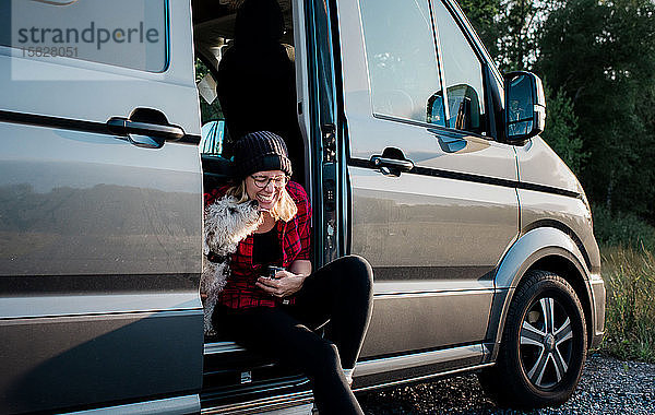 Hund leckt Frau beim Kaffeetrinken im Wohnmobil das Gesicht