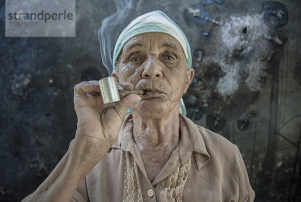 Alte Frau raucht Pfeife in einem brasilianischen Dorf im Norden