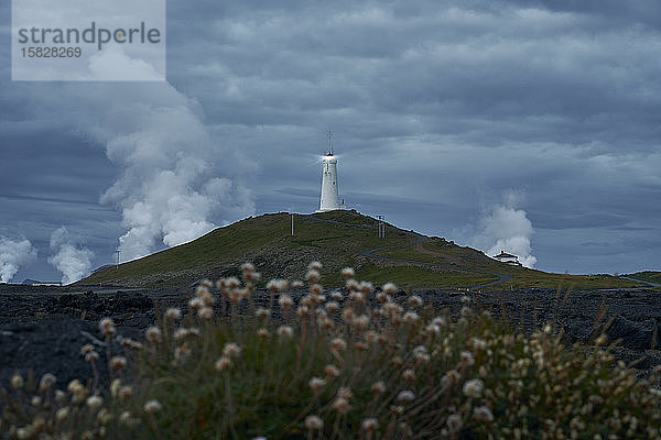 Landschaft mit weißem Leuchtfeuer auf einem Berg auf einer Insel