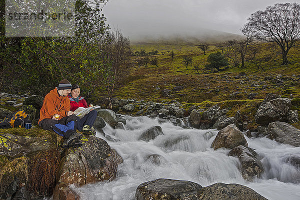 Ehepaar beim Kartenlesen auf dem Weg nach Scafell Pike im Lake District