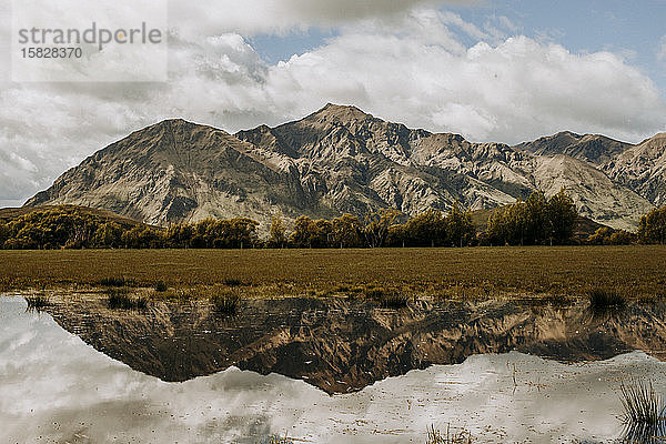 Roys Peak Neuseeland spiegelt sich in einer Wasserlache bei Wanaka