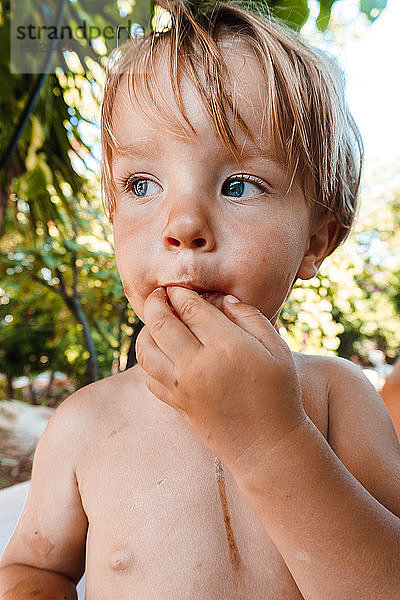 Kleiner Junge isst eine Beere