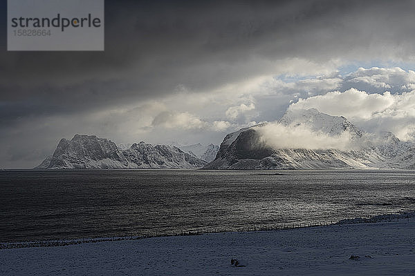 Dramatisches Licht der Wintersturmwolken  die Ã?ber die entfernten Berge von VestvÃ¥gÃ¸y  Lofoten  Norwegen