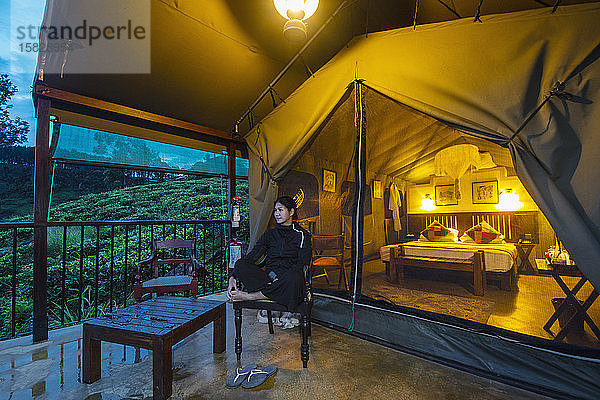 Frau entspannt sich vor einem Luxuszelt in einer Lodge in Sri Lanka