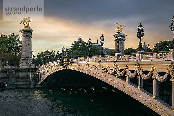 Pont Alexandre III mit dem Petit Palais im Hintergrund bei Sonnenuntergang