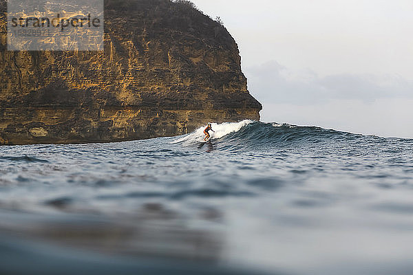 Junge Frau beim Surfen im Indischen Ozean