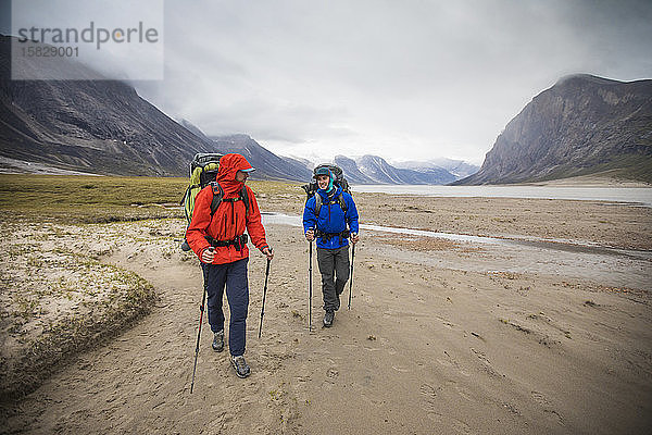Frontansicht von Rucksacktouristen beim Wandern im Regen  Baffin Island  Kanada.