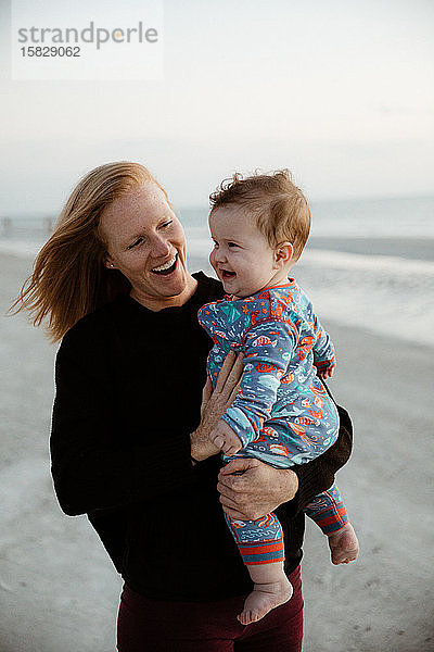 junge Mutter und gesunder pummeliger Junge Kind lächelt beim Strandspaziergang