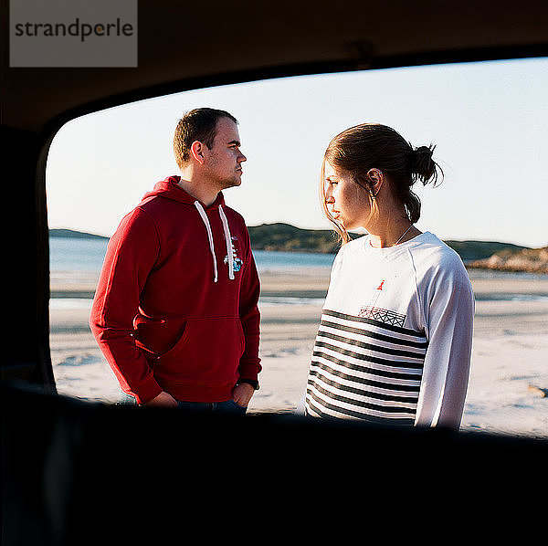 Mann und Frau stehen an der Meeresküste