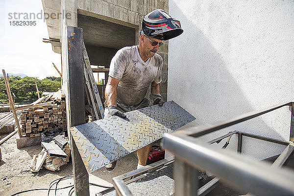 Mann arbeitet auf der Baustelle  baut Treppenhaus.