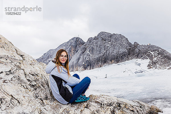 junges tausendjähriges Mädchen geniesst die Aussicht auf die Alpen auf einem Gletscher