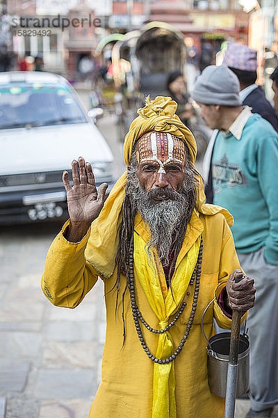 Ein Sadhu  ein heiliger hinduistischer Mann  hält auf einer Straße in Kathmandu  Nepal  inne.