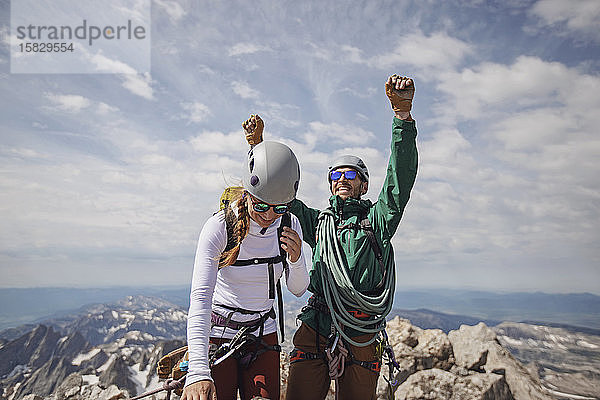 Lächelndes Paar feiert das Erreichen des Gipfels des Grand Teton