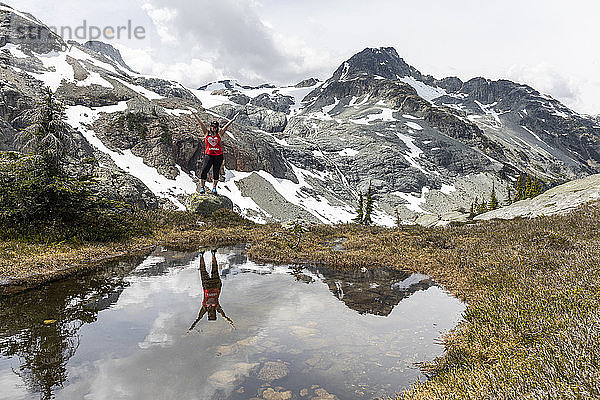 Eine Frau steht auf einem Felsen und feiert Kanada an einem Sommertag in den Bergen von Britisch-Kolumbien.