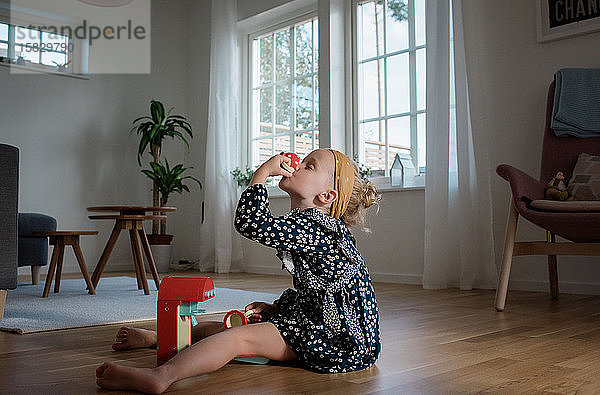 junges Mädchen  das zu Hause mit einer Spielzeug-Kaffeemaschine spielt