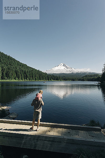 Ein Vater trägt seine Tochter am Trillium Lake  OR  auf den Schultern.