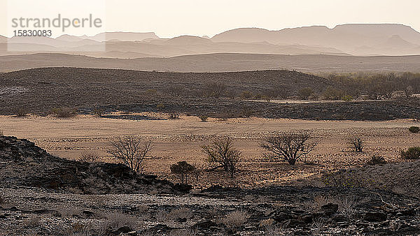 hügelige und trockene Landschaft der namibischen Wüste bei Sonnenaufgang
