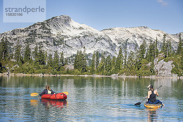 Mutter und Tochter genießen das Bootfahren auf dem schönen blauen Alpensee