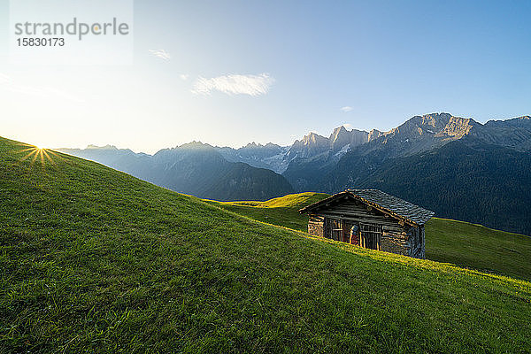 Sonnenausbruch auf Wiesen und Hütte  Tombal  Soglio  Schweiz