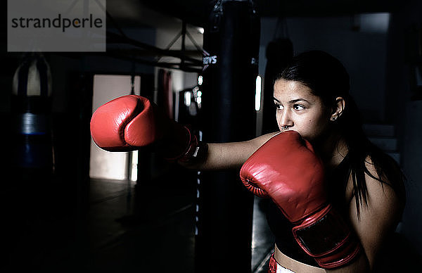 junge Frau  die im Fitnessstudio Boxen übt