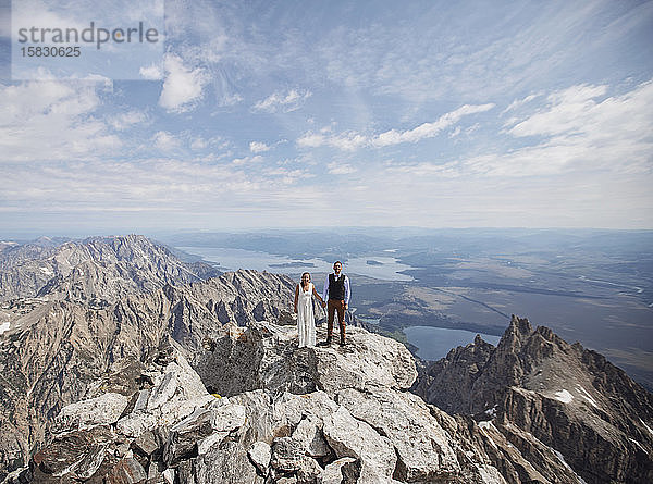 Braut und Bräutigam stehen auf dem Gipfel des Grand Teton  nachdem sie geheiratet haben.