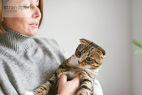 Frau hält schöne Katze auf weißem Hintergrund