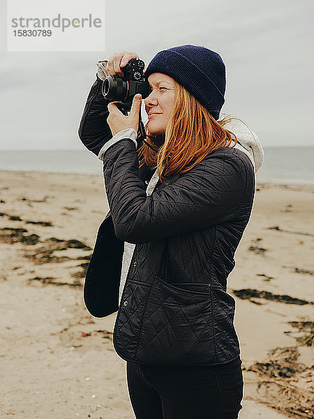 Frau fotografiert am Strand in Schottland