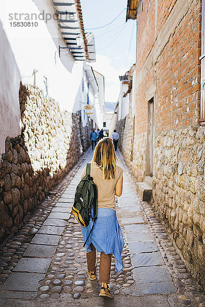 Eine junge Frau geht die Straße in der Stadt Cusco  Peru  entlang