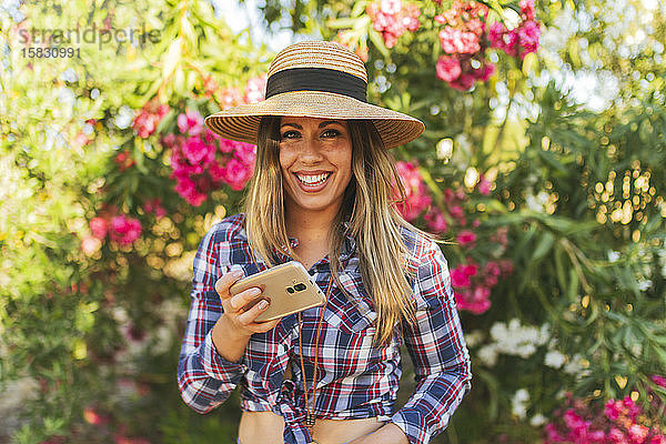 Porträt einer jungen Frau mit Telefon in der Hand  in Karo gekleidet