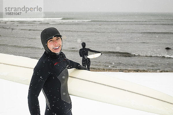 Frauen bereiten sich an einem verschneiten Tag auf das Surfen vor